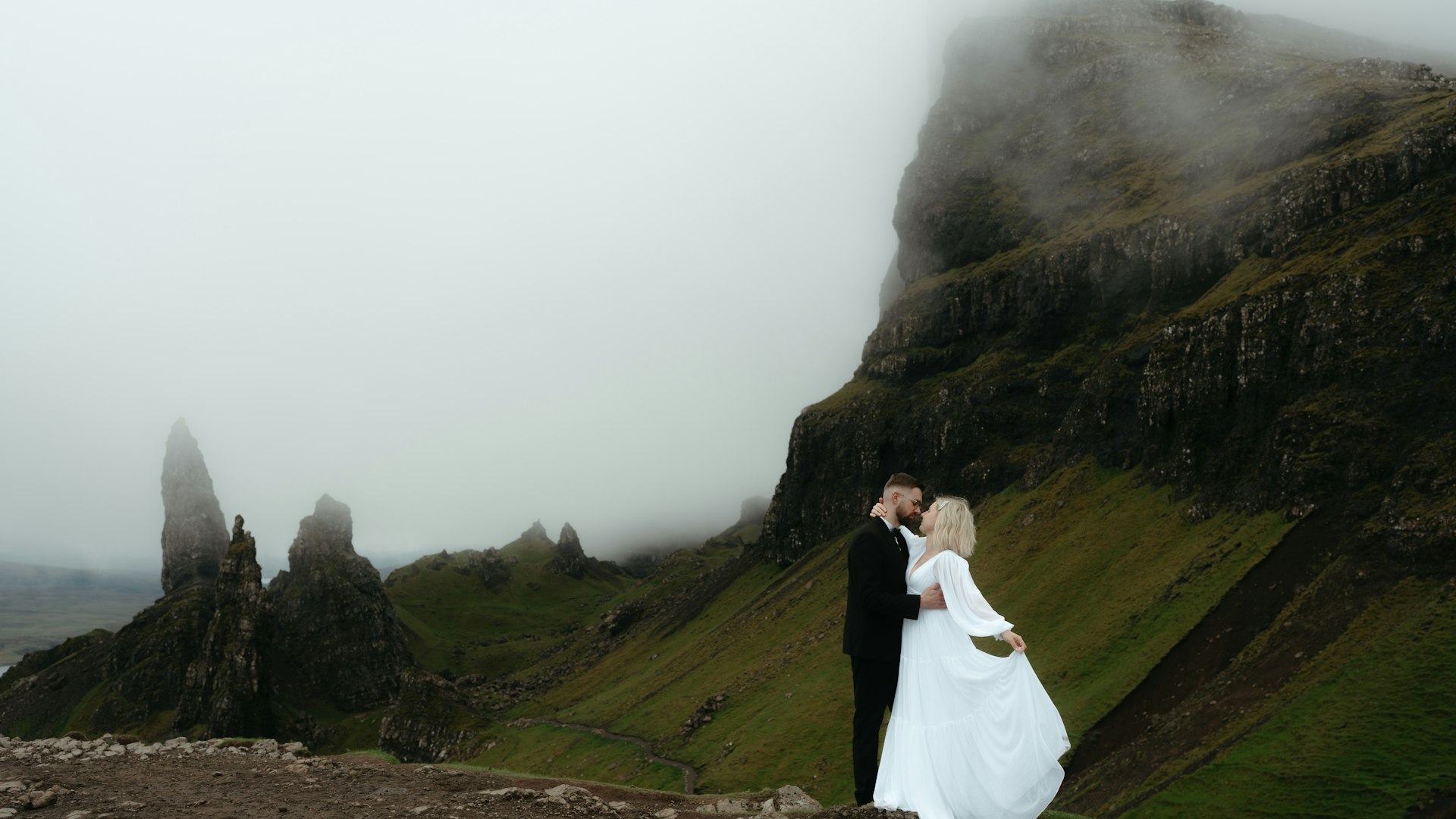 Brautpaar umarmt sich vor Bergkulisse — Berghochzeit in den Alpen