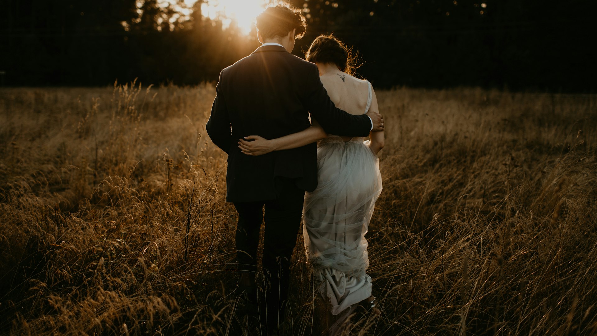 Brautpaar umarmt sich im goldenen Feld bei Sonnenuntergang — Hochzeit in der Toskana